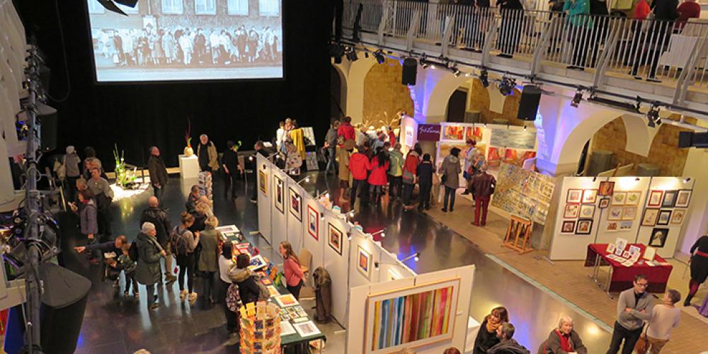 Ein großer Raum mit Kunst und vielen Menschen