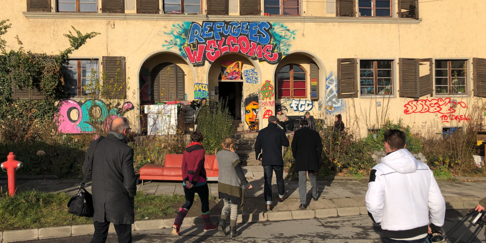 Ein Haus mit Menschen im Vordergrund