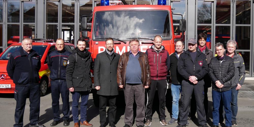 Eine Gruppe von Menschen vor einem Feuerwehrwagen