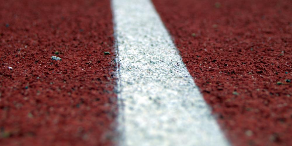 weiße Markierungslinie auf dem Boden eines Sportplatzes in Nahaufnahme