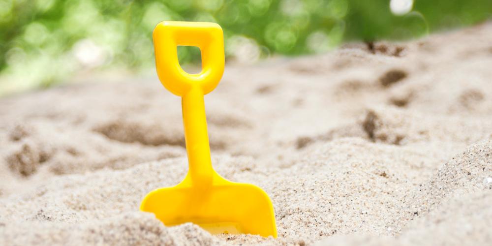 Eine Spielschaufel in einem Sandkasten