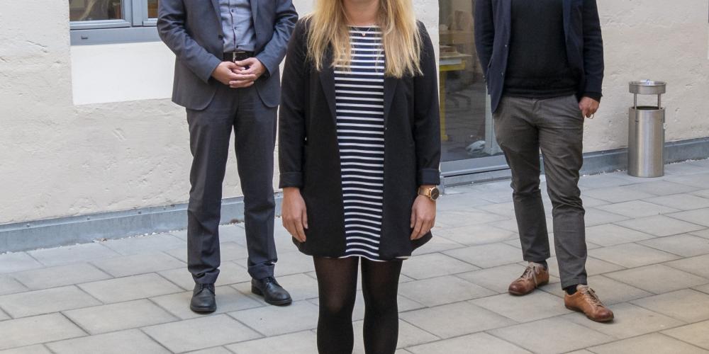 Drei Personen schauen in die Kamera