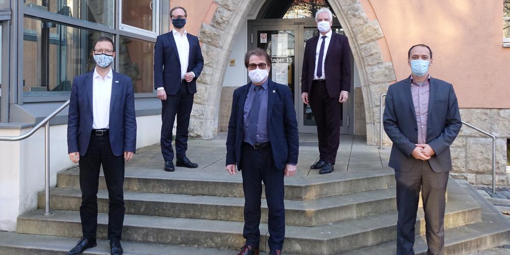 Fünf Männer stehen auf der Treppe vor dem Gebäude Anger 15