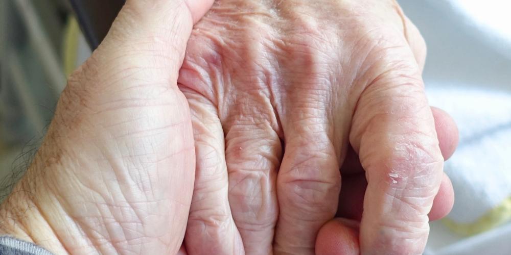 Bei Hände, eine davon von einer älteren Person
