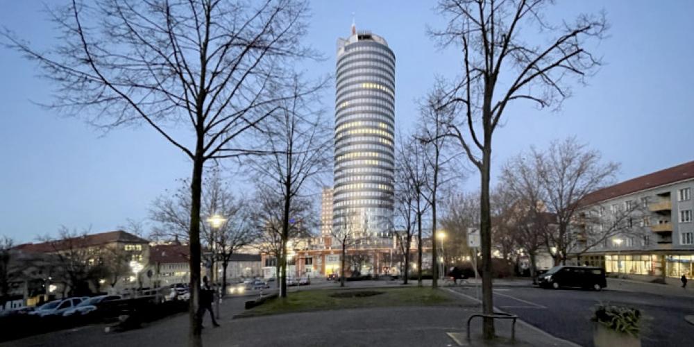 Der Jentower im Vordergrund zwei Bäume ohne Blätter