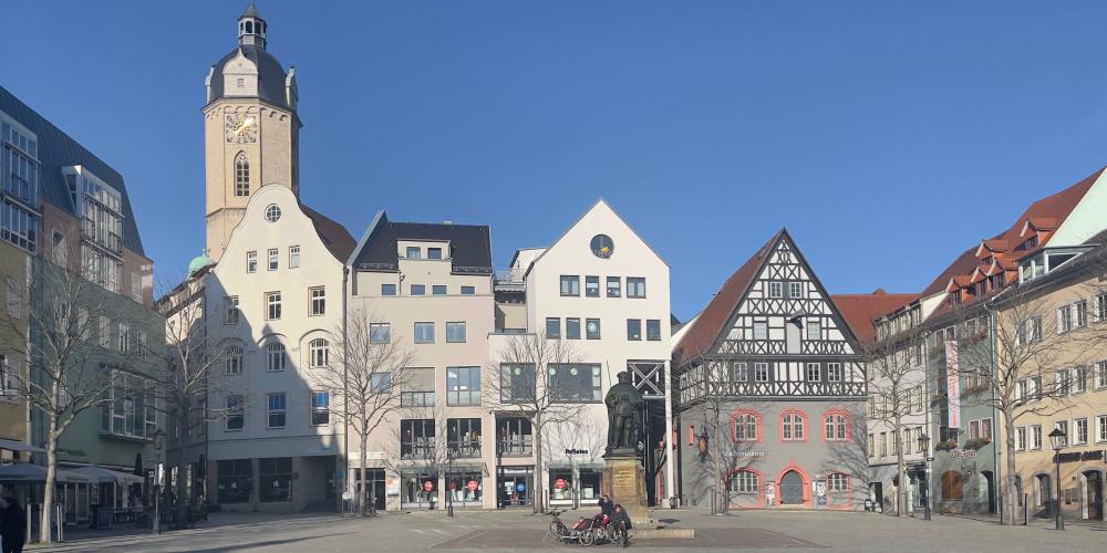 Eine Platzmit Denkmal, im Hintergrund Häuser