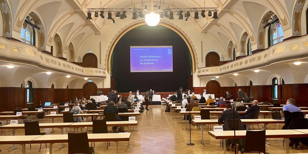 Ein großer Saal mit Tischen, an denen Menschen sitzen