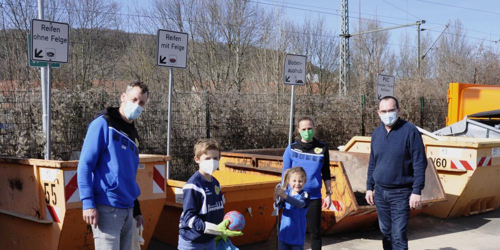 Drei Erwachsenen und zwei Kinder ahebn Mülltüten in der Hand