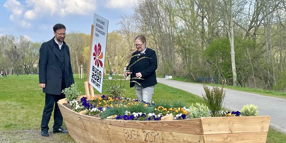 Zwei Menschen hinter einem Blumenbeet in Form eines Bootes