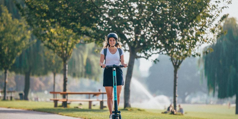 Frau auf E-Scooter im Park