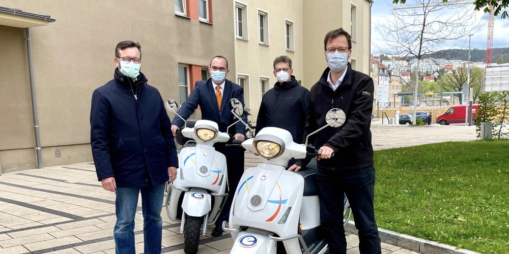 Vier Männer mit zwei Motorrollern