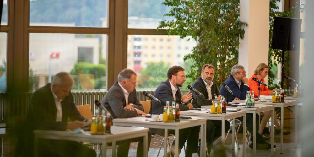 Sechs Männern und eine Frau an einem Tische