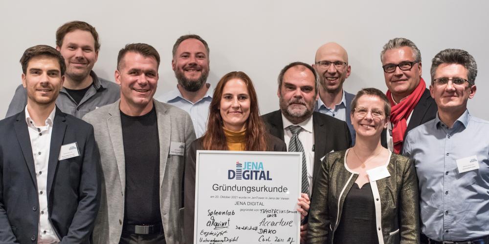 Mehrere Personen haben sich aufegstellt und halten ein großes Schild vor sich