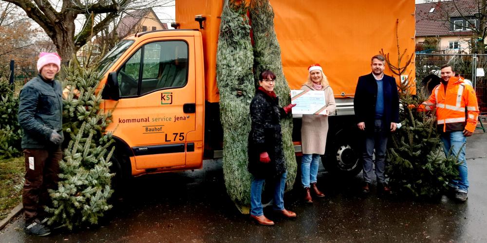 Fünf Menschen halten Weihnachtsbäume