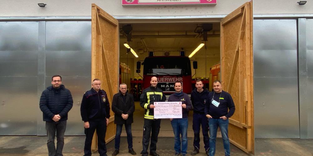 Feuerwehrmänner halten einen Scheck 