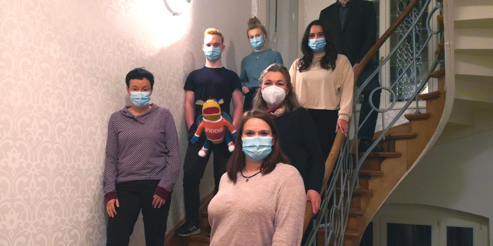 Viele Menschen auf ein Treppe, alle tragen Maske