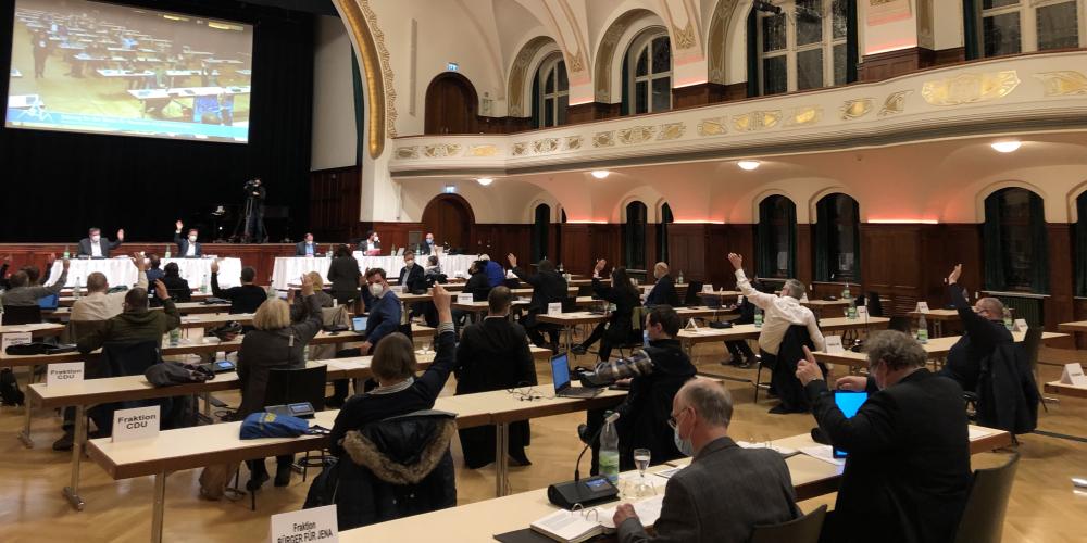 Ein großer Saal mit Menschen am Tisch