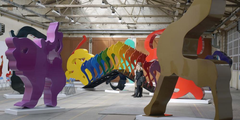 Mehrere große farbige Skulpturen stehen in einem großen hellen Raum.