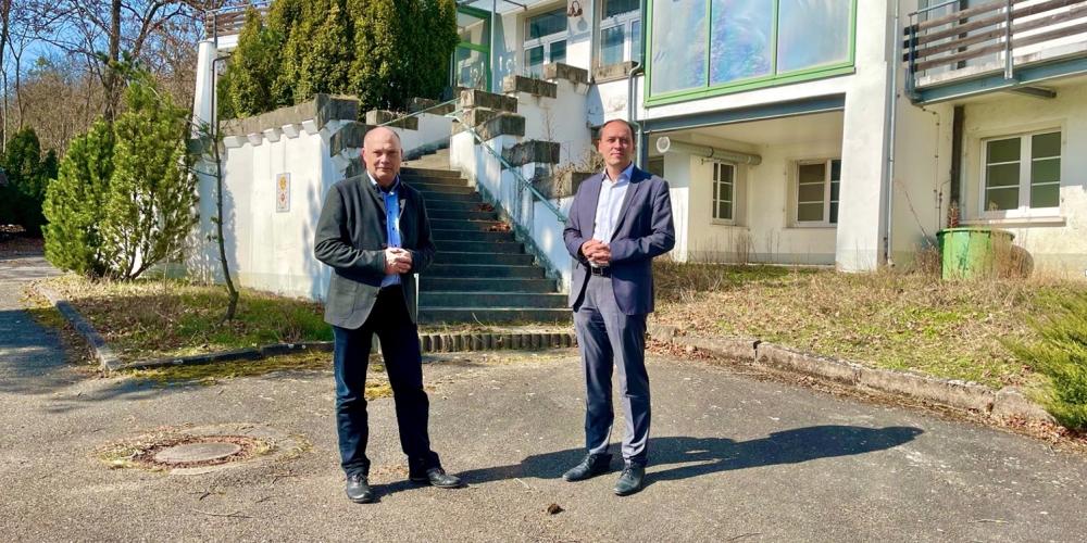 Zwei Menschen vor einer Villa