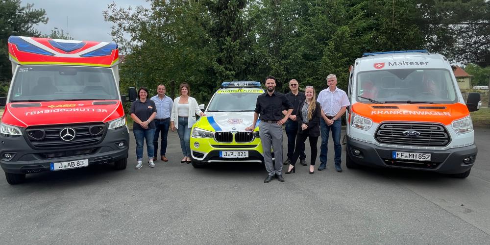 Rettungswagen mit Personen, die in die Kamera schauen