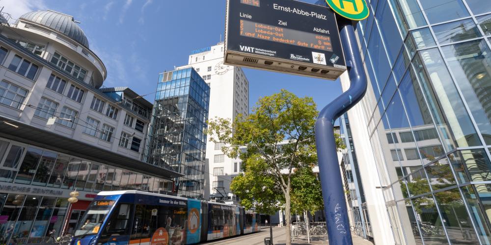 Ein urbaner Platz mit Industriebauten und einer Straßenbahn