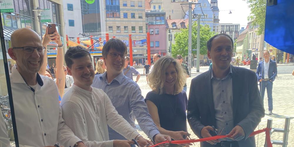 Menschen schneiden zur Eröffnung ein Band durch