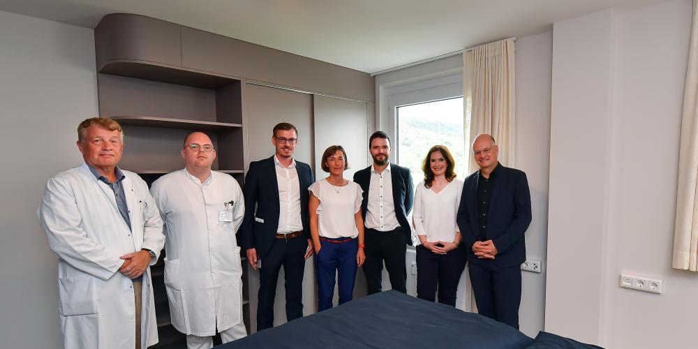 Gruppenbild aller an den Gesundheitsapartments Beteiligten: Klinikdirektor Prof. Dr. Utz Settmacher vom Universitätsklinikum Jena (UKJ), Felix Donndorf, leitender Oberarzt am UKJ, Projektleitung Mandy Steinbrück von den Stadtwerken Energie, Projektleiter Stefan Albert vom UKJ, Benjamin Koppe, Dezernent für Finanzen, Sicherheit und Bürgerservice, Dorothea Prell, Digitalisierungsbeauftragte der Stadt Jena sowie Stadtwerke-Geschäftsführer Tobias Wolfrum.