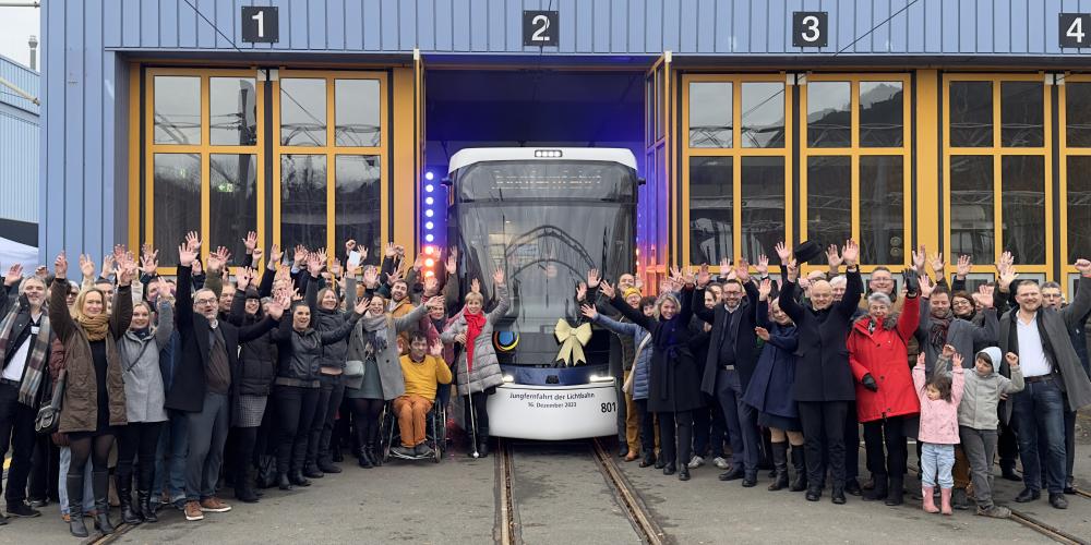 Viele Menschen begrüßen eine Straßenbahn