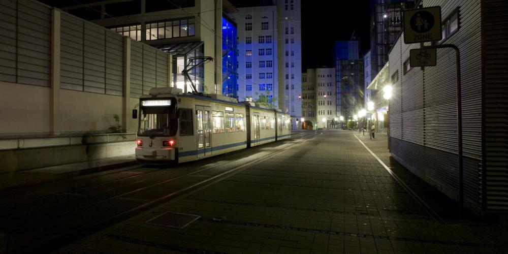 Straßenbahnhaltestelle bei Nacht.