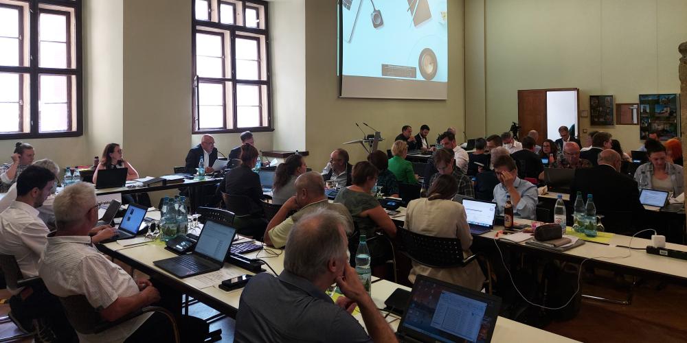 Mitglieder des Stadtrates sitzen an Tischen im Historischen Rathaus