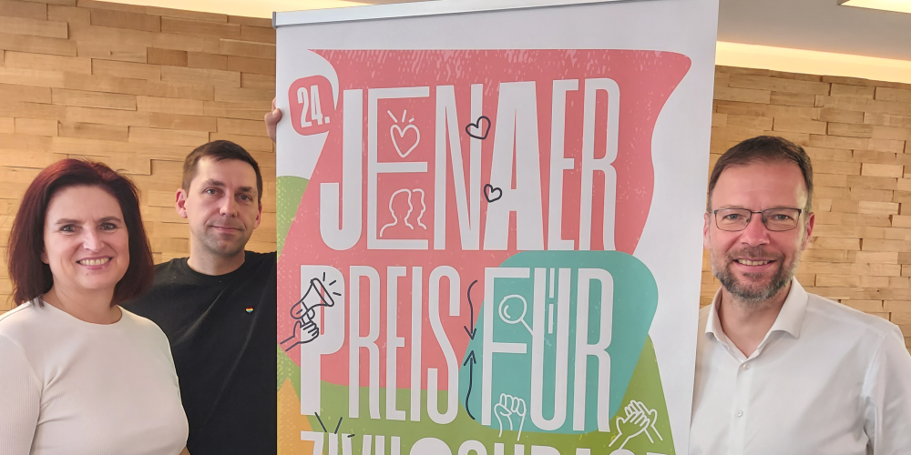 Drei Personen neben einem Roll-up.