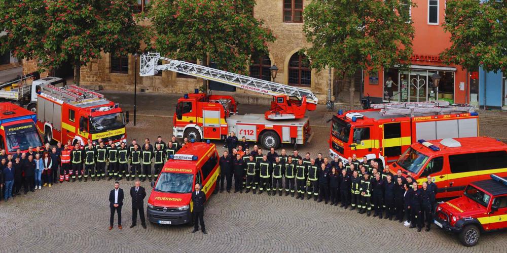 Viele Feuerwehrleute stehen vor dem Rathaus.