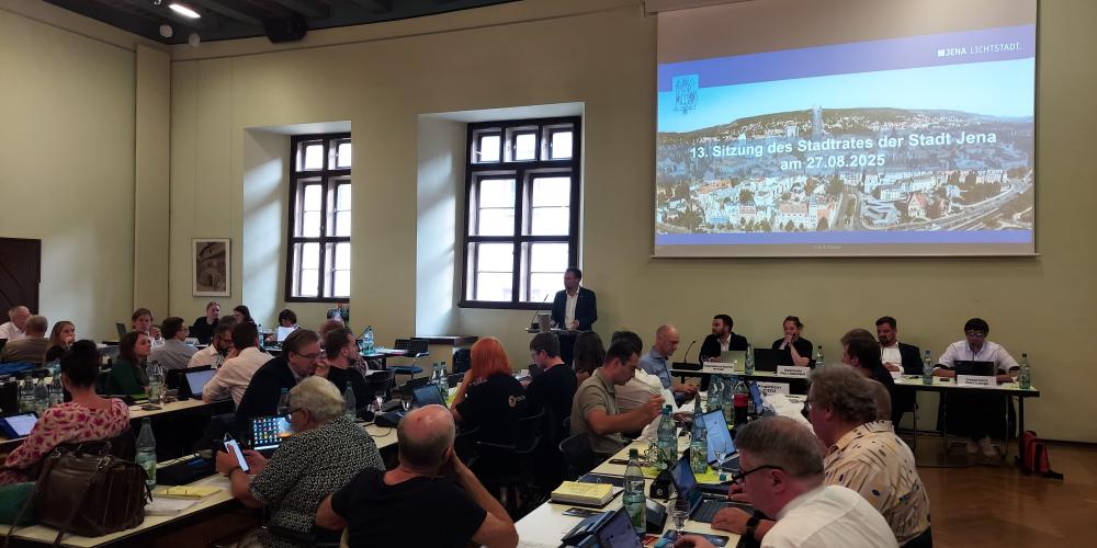 Stadtratsmitglieder im Rathaus sitzen an Tischen, Oberbürgermeister Dr. Thomas Nitzsche spricht am Rednerpult