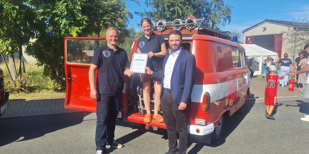 Drei Personen lachen in die Kamera.