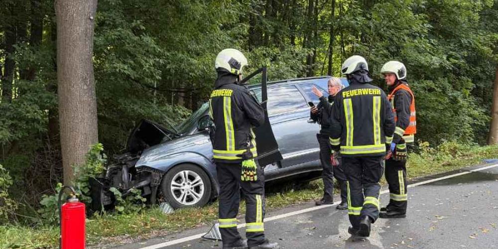 Polizei und Feuerwehr steht um einen Unfallwagen herum.