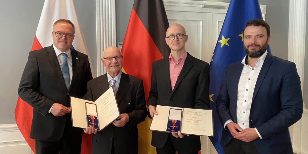 Vier Männer schauen in die Kamera.