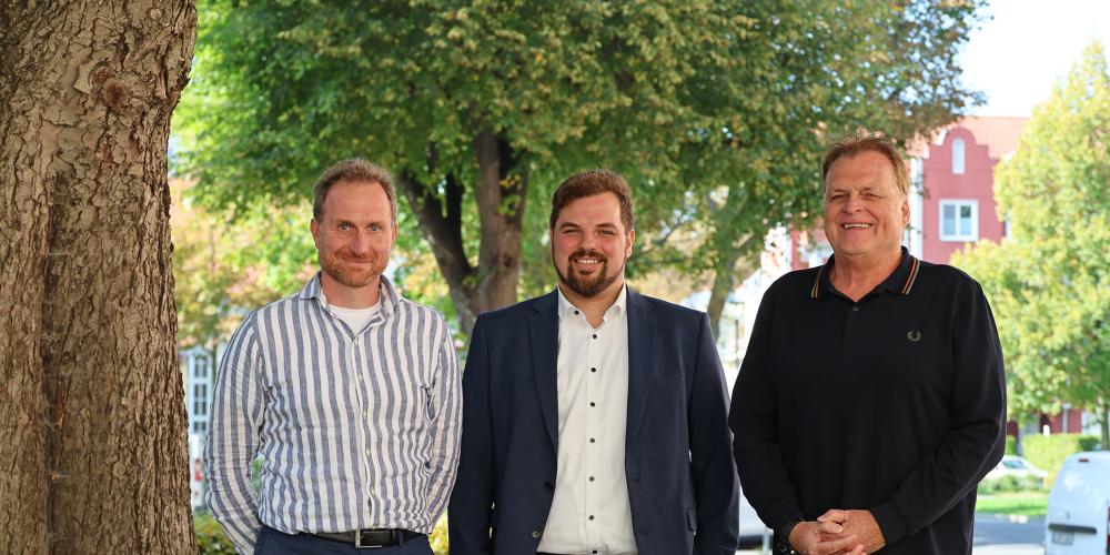 Drei Personen stehen nebeneinander