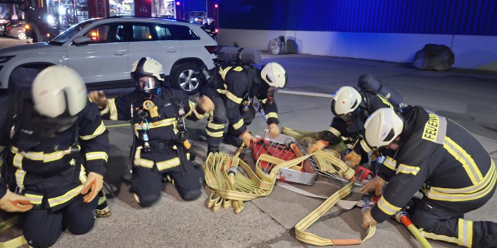 Mehrere Feuerwehrleute sortieren Schlauch