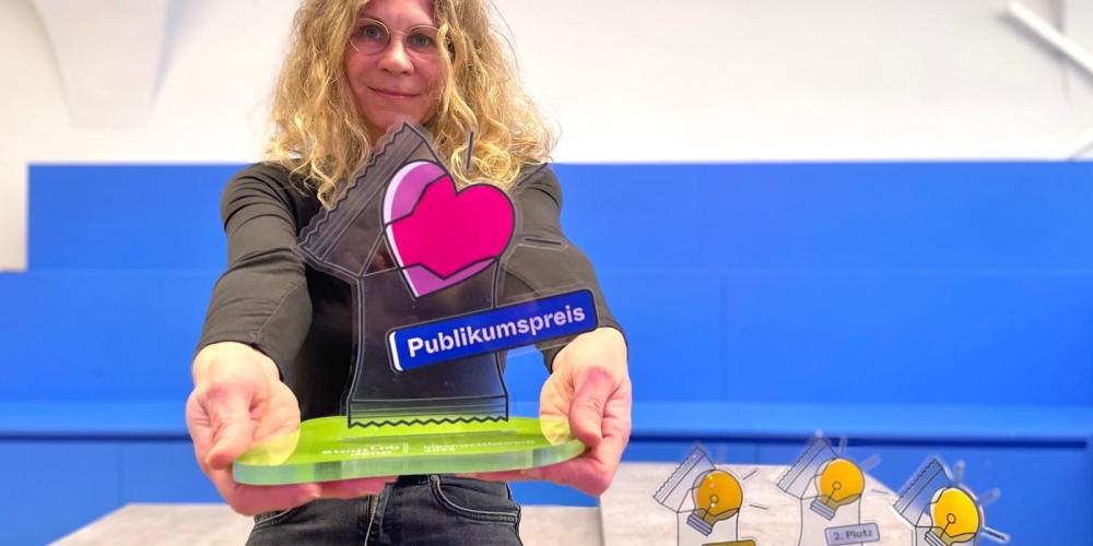 StadtLab-Projektmanagerin Grit Sachse präsentiert einen der Pokale für den StadtLab Ideenwettbewerb 2025.