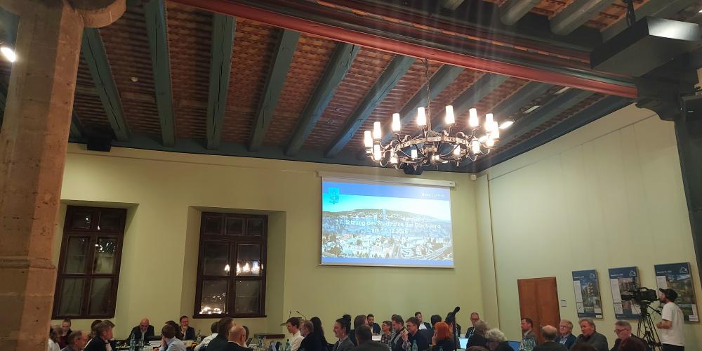 Mitglieder des Stadtrates sitzen im Historischen Rathaus an Tischen