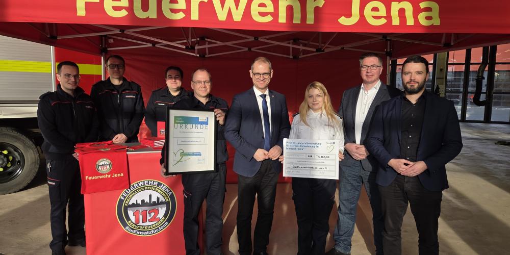 Mehrere Personen stehen vor einem Pavillon der Feuerwehr Jena und schauen in die Kamera.