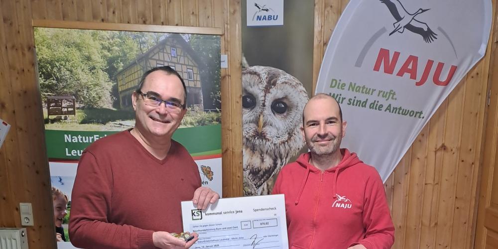 Eine Person überreicht eine anderen eine Spendenquittung.