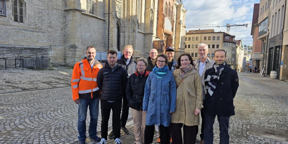 Mehrere Menschen stehen auf dem Kirchplatz in Jena und schauen in die Kamera.