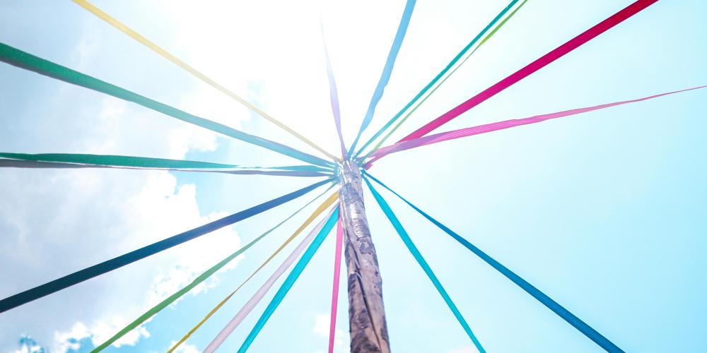 Bunte Fahnen hängen am Baum.