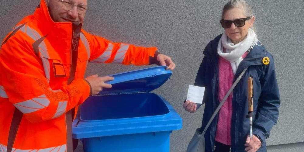 Martin Steglitz und Beatrix Adloff haben den ersten Aufkleber auf einer blauen Tonne angebracht.
