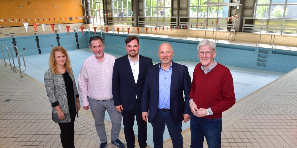 Stehen vor dem leeren Schwimmbecken in der ehemaligen Schwimmhalle: Katrin Hitziggrad (Blank – Agentur für Zwischennutzung), Jörg Hühn (Geschäftsführer reCoVer Stiftung Jena), Dezernent Johannes Schleußner, Bernhard Dengel (Geschäftsführer Jenaer Bäder) und Ortsteilbürgermeister Volker Blumentritt (v. l.)