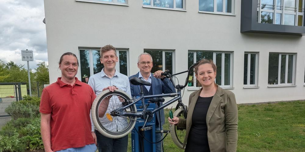 Vier Personen stellen die Fahrrad-Reparaturstation vor