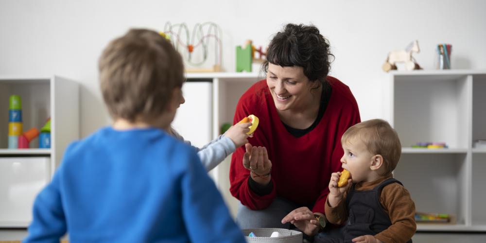Frau hilft Kleinkindern