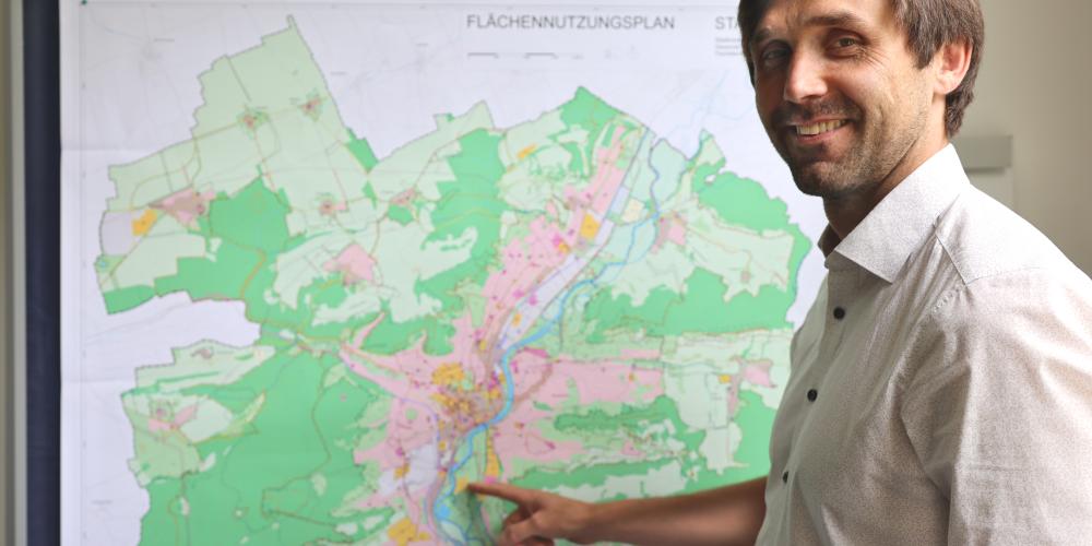 Dezernent Dirk Lange zeigt auf den neuen Flächennutzungsplan der Stadt Jena