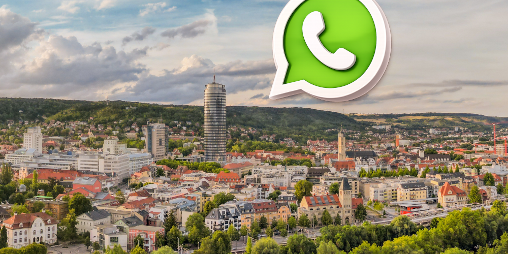 Auf einem Panoramabild der Stadt Jena ist das WhatsAppLogo zu sehen (eine Sprechblase mit Telefonhörer)